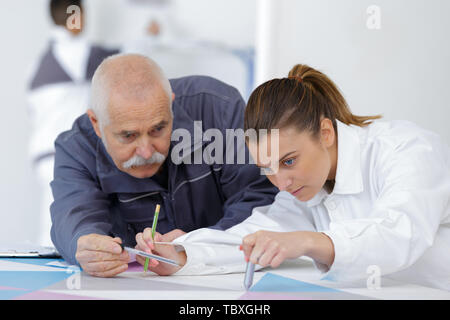 female apprentice with male decorator in training Stock Photo
