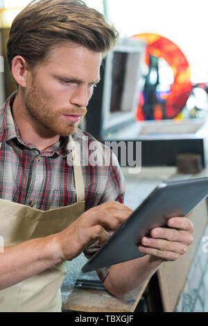 shoemaker using digital tablet in workshop Stock Photo