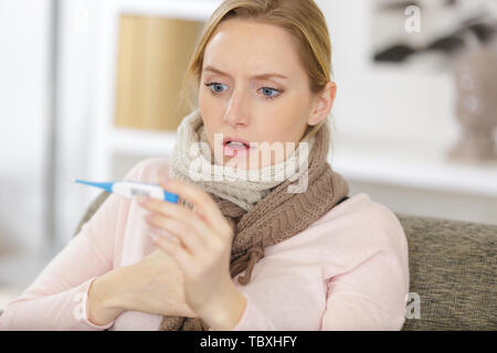 woman being sick having flu lying on sofa Stock Photo