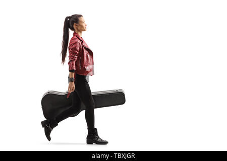 Full length profile shot of a female musician walking and carrying a guitar in a case isolated on white background Stock Photo