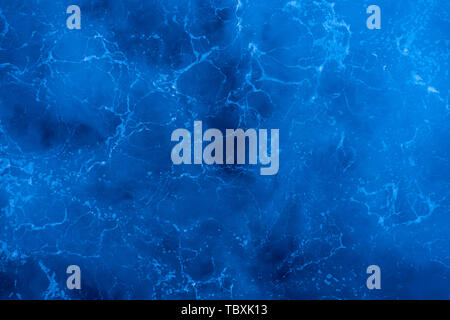 Dark blue deep sea surface, rippled water with sea foam and sparkling light Stock Photo