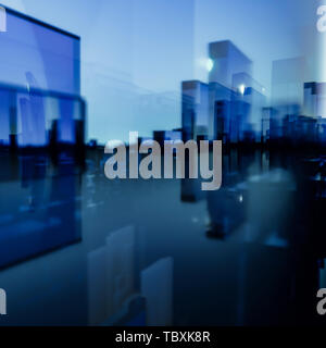Abstract cityscape of three dimensional blue and red rectangular glass polygons against a blue sky with glow on the horizon Stock Photo
