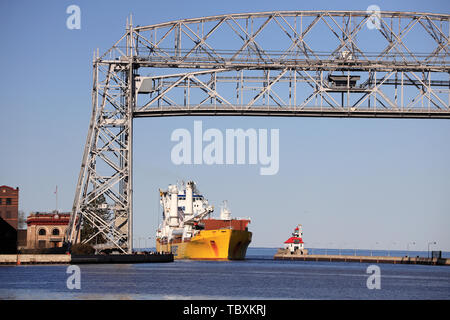 A ship passing through the Aerial Life Bridge enter Duluth Harbor Basin. Duluth.Minnesota.USA Stock Photo