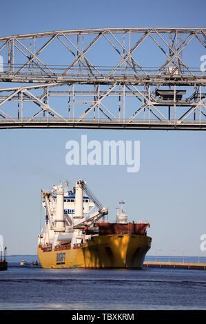 A ship passing through the Aerial Life Bridge enter Duluth Harbor Basin. Duluth.Minnesota.USA Stock Photo