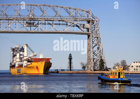 A ship passing through the Aerial Life Bridge enter Duluth Harbor Basin. Duluth.Minnesota.USA Stock Photo