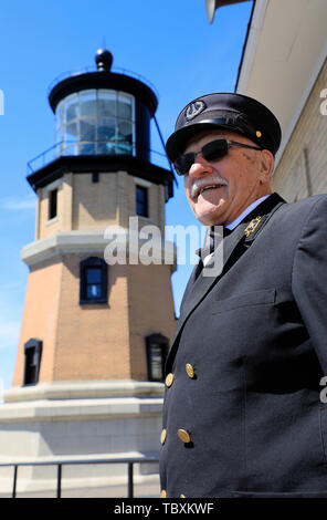 A male guide in traditional lighthouse keepers' uniform posing by the ...