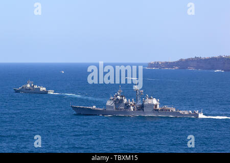 USS Chosin (CG-65) Ticonderoga-class guided-missile cruiser and Royal Australian Navy Anzac-class frigate HMAS Parramatta sailing at sea. Stock Photo