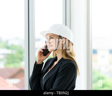Female engineer is making call in office building Stock Photo