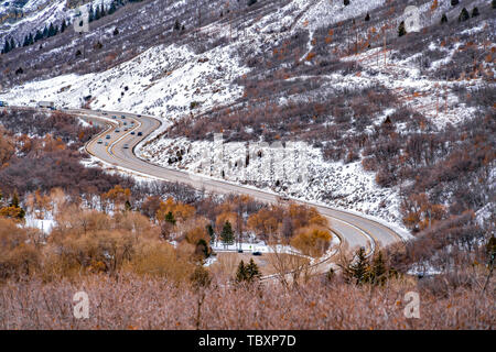 Panorama of a road that winds through an immense mountain with snow in winter Stock Photo