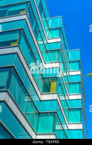 Modern building exterior viewed from below with blue sky in the background Stock Photo