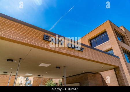 Exit Only sign on the exterior of a building against blue sky on a sunny day Stock Photo