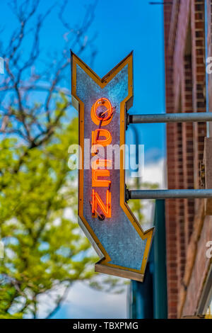 Red brick building with an Open arrow sign viewed on a sunny day Stock Photo