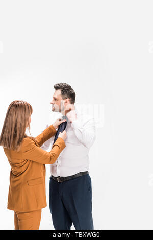 woman in suit adjusting tie of overweight man isolated on white with copy space Stock Photo