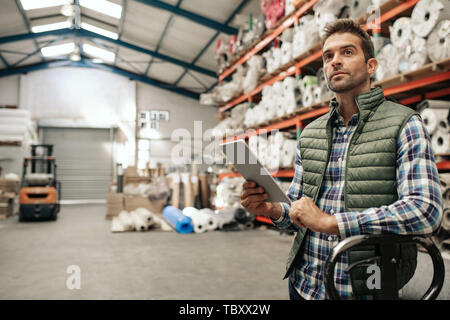 Warehouse worker checking stock using a digital tablet Stock Photo