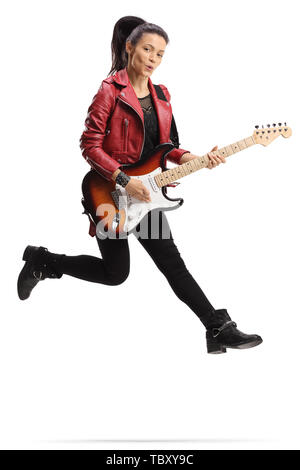 Full length shot of a young female guitarist playing a bass guitar and jumping isolated on white background Stock Photo