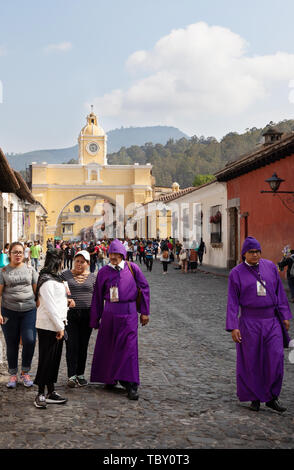 Antigua Guatemala holy week - local people in traditional religious costume in the street, with Santa Catalina arch, Antigua Guatemala Latin America Stock Photo