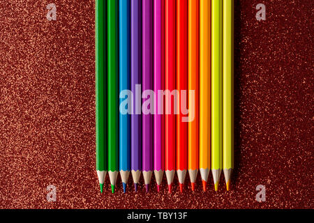 Colored pencils on glitter red background Stock Photo