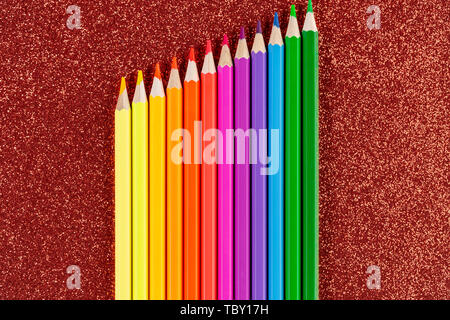 Colored pencils on glitter red background Stock Photo