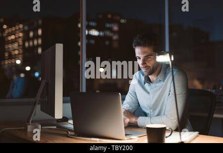 Young businessman working overtime late in the evening Stock Photo