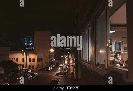 Smiling young businessman working in his office at night Stock Photo