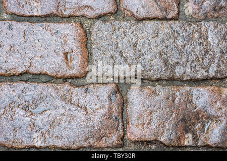 Fragment of cobblestone pavement, wet after rain, for use as an abstract background and texture. Stock Photo