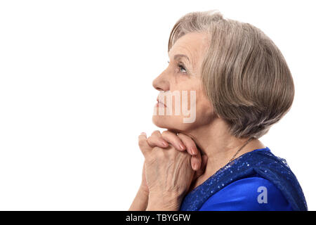 Happy elder woman in elegant dress praying isolated Stock Photo