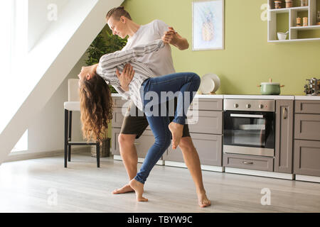 Adorable loving couple dancing in kitchen at home Stock Photo