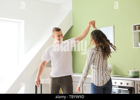 Adorable loving couple dancing in kitchen at home Stock Photo