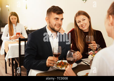 Gentleman with elegant women are having dinner in luxury restaurante indoor. Stock Photo
