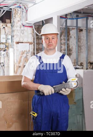 Construction worker using handheld circular saw at indoors building site Stock Photo