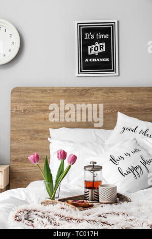 Tray with tasty breakfast on bed Stock Photo