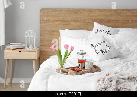 Tray with tasty breakfast on bed Stock Photo
