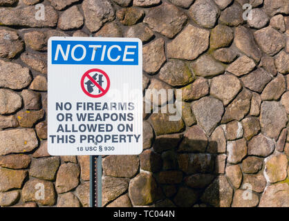 Warning sign notice no firearms or weapons allowed on this property at entrance to the National Cemetery in Bourne, Cape Cod, Massachusetts USA Stock Photo