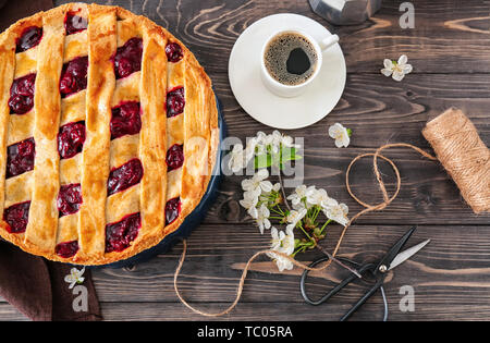 Composition with tasty cherry pie and cup of coffee on wooden table Stock Photo