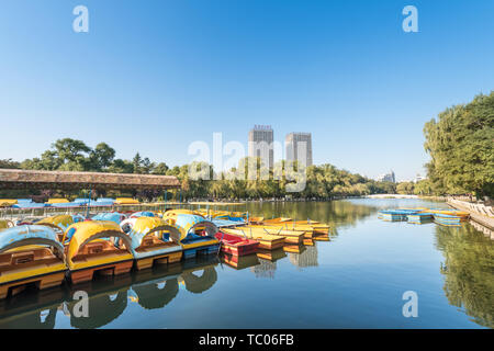 Autumn China Fushun early morning park river bank willow stone bridge cruise ship Stock Photo