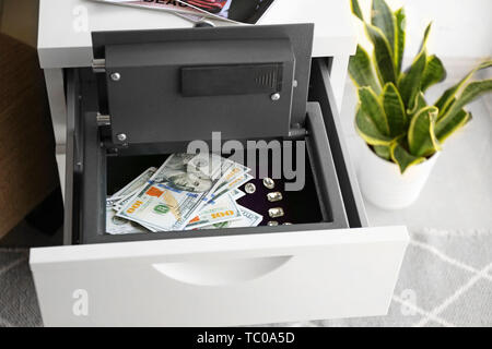 Small modern safe with money in cabinet drawer Stock Photo