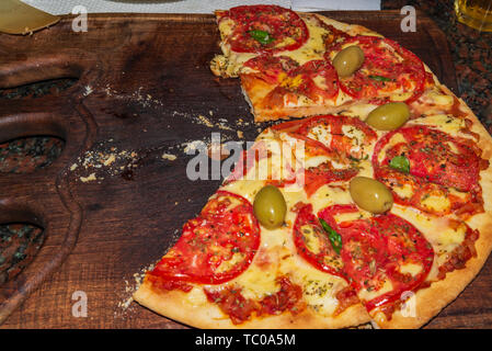 Pizza. Fresh Italian neapolitan, basil and tomato on a wooden table Stock Photo