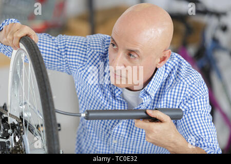 man pumping up the tires on his bicycle Stock Photo