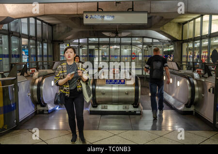 Escalators on the District Line platform at Westminster London Underground Station lead to the Jubilee Line Stock Photo