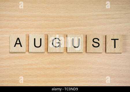 The word March, spelt out using wooden tiles on a wood effect background. Stock Photo