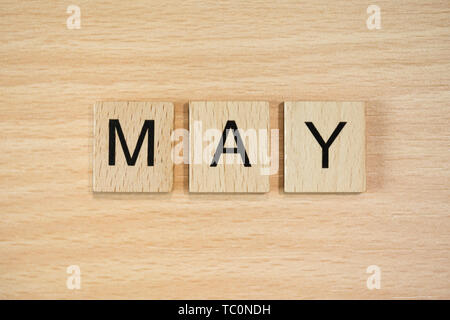 The word March, spelt out using wooden tiles on a wood effect background. Stock Photo