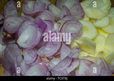 A close-up of Garlic sliced & red onion sliced. Concept healthy fresh organic red onion - eating super food on rustic wood kitchen chopping board Stock Photo