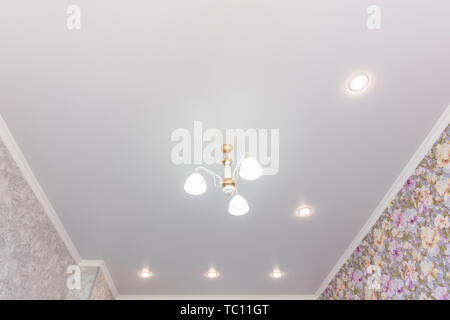 Stretch ceiling in the room with a chandelier and spotlights Stock Photo
