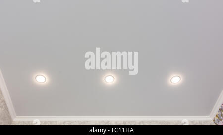 Fragment of the stretch ceiling with three spotlights in a row Stock Photo