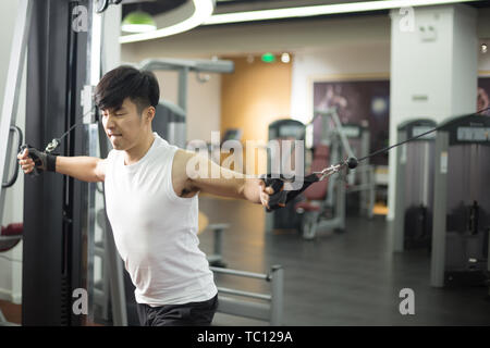 young handsome asian man works out in modern gym Stock Photo