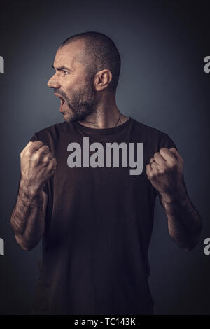 Satisfied and happy man posing with clenched fists as a sign of success. Stock Photo