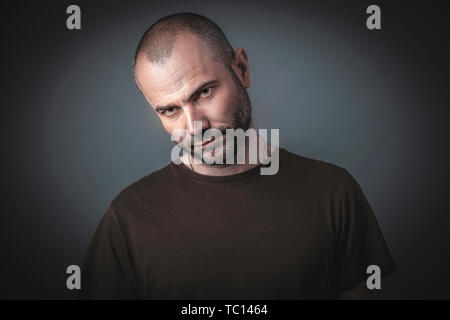 Portrait of man with confident and threatening look. Shot taken in the studio. Stock Photo