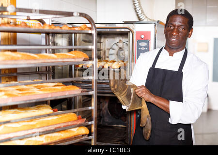 Handsome African American Baker Tray Fresh Loaves Bread Baking Manufacture  Stock Photo by ©ArturVerkhovetskiy 186864520