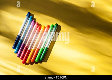 Set of multicolored marker pens on the yellow background in a row for drawing creativity Stock Photo