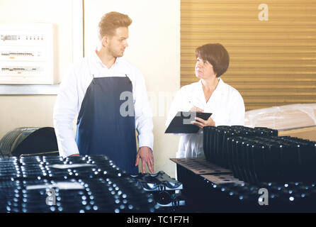 Diligent employees checking number of wine bottles at sparkling wine factory Stock Photo